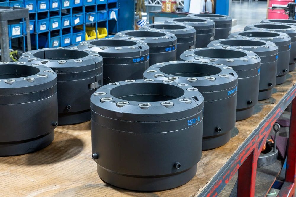 CAMTOP C21-P casing hanger assembly production run — black manual seal slip-type hangers arranged on workshop bench in manufacturing facility
