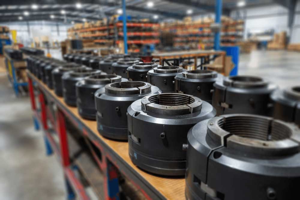 CAMTOP C-22 casing hanger production run — black automatic sealing slip-type hangers with machined slip bowls arranged on workshop bench