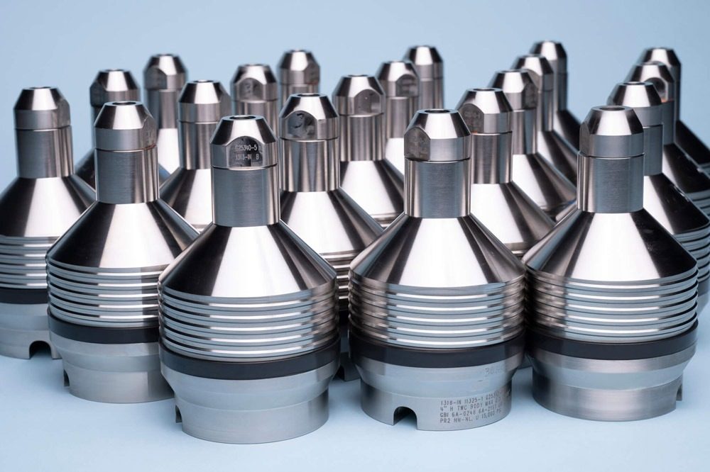 CAMTOP Type H two-way check valves production run — rows of black nitride TWCV check valves arranged on workshop bench